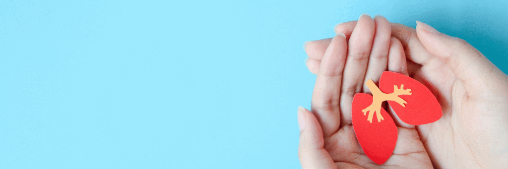COPD Treatment - COPD Treatment - Pair of hands holding a red paper cut-out representing human lungs against a blue background.
